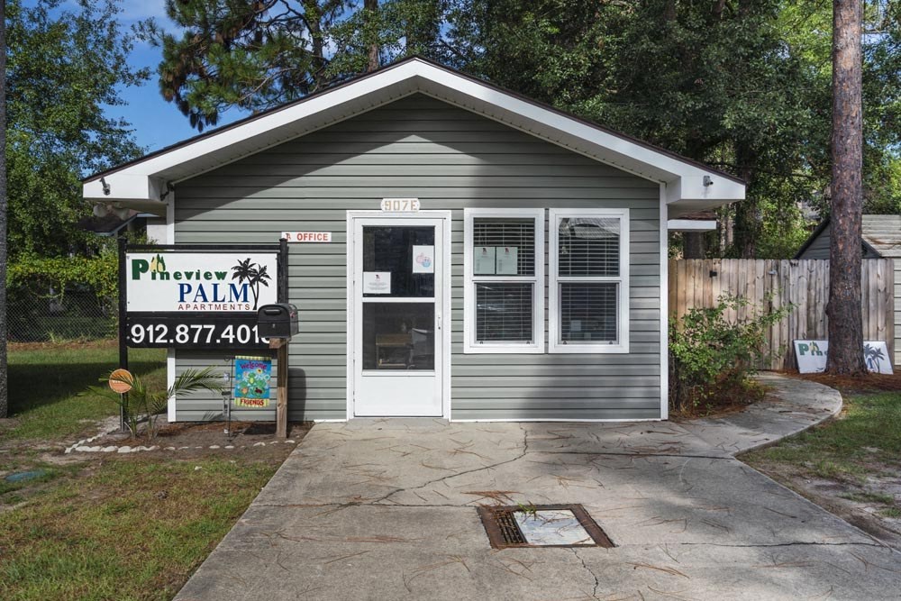 a small gray building with a sign that says pavement palm