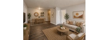 A living room with a white couch, wooden coffee table, and a rug.