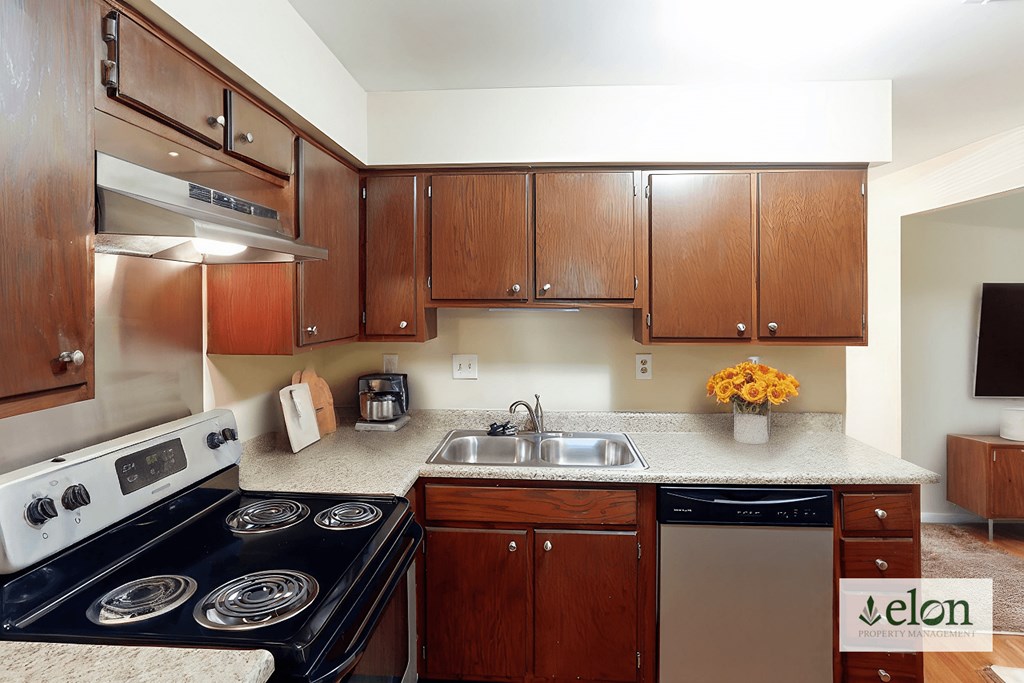 A kitchen with wooden cabinets and a stove top oven.