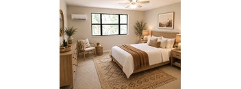 A bedroom with a large bed, a chair, and a rug.