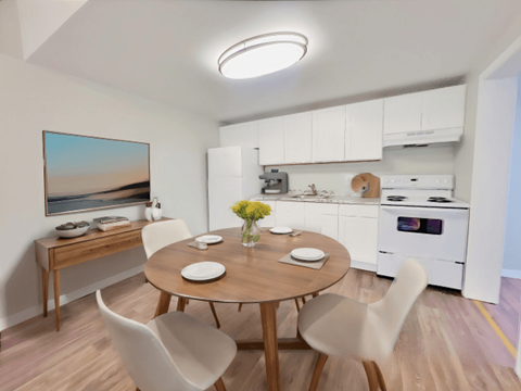 A modern dining room with a round table and chairs.
