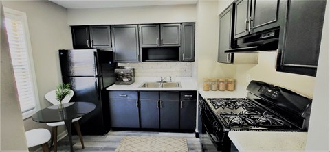 a kitchen with black appliances and black cabinets