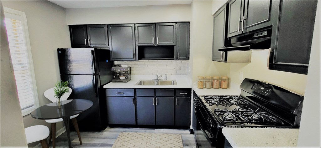 a kitchen with black appliances and black cabinets