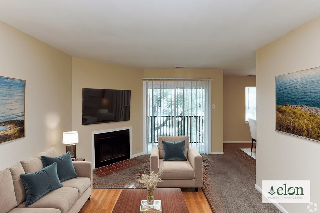 A living room with a couch, a chair, a coffee table, and a fireplace.