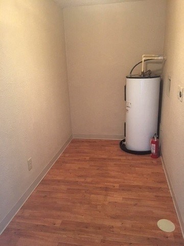 an empty room with a water heater in the corner