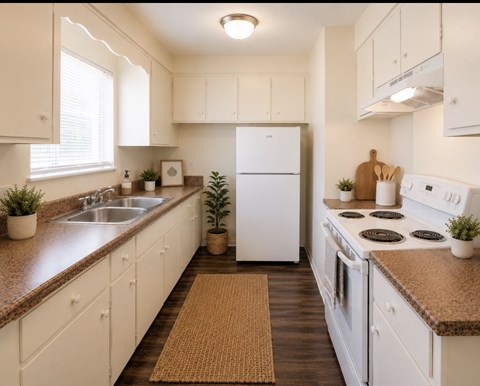 A kitchen with white appliances and wooden cabinets.