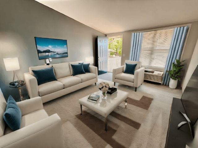 A living room with a white sofa set and a painting on the wall.