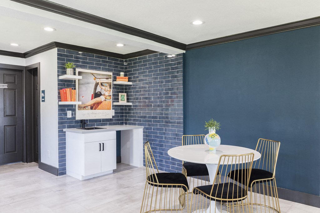 a dining room with blue walls and a white table and chairs