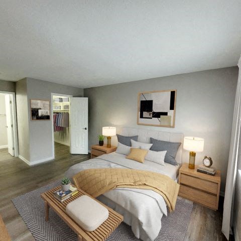 Bedroom with hardwood-style flooring and a walk-in closet.