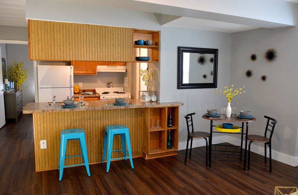 a kitchen with a breakfast bar and a table with blue stools