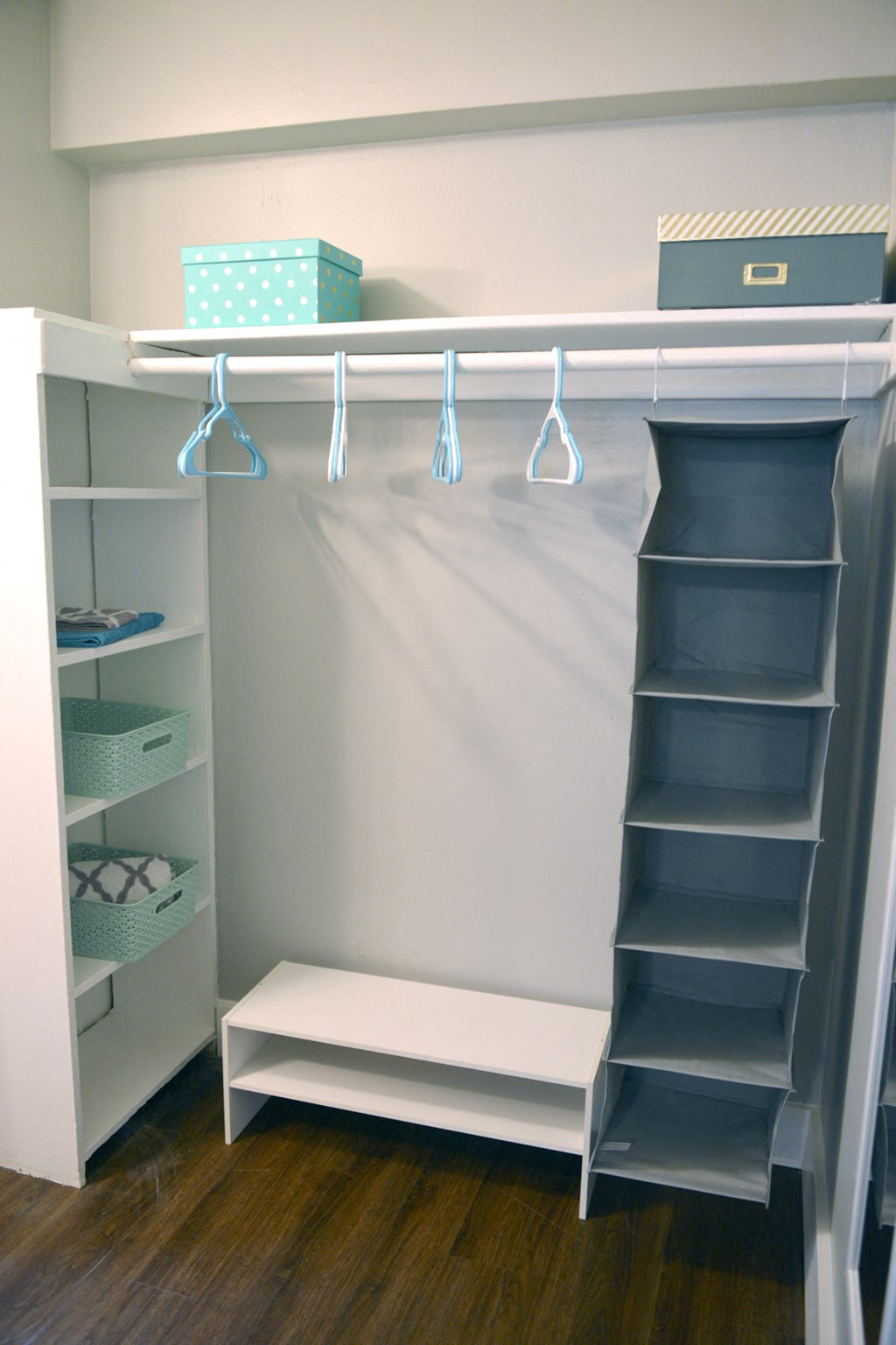 a walk in closet with a shelving unit and a closet organizer