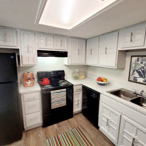 Kitchen with black appliances and white cabinets. 