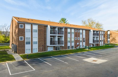 A large brick building with a parking lot in front.