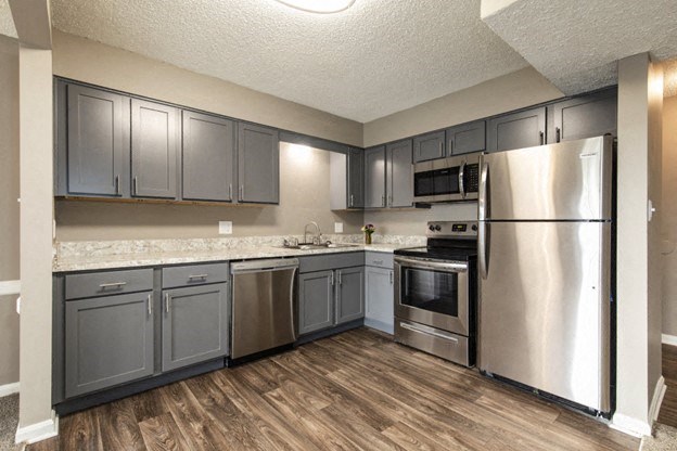 a kitchen with stainless steel appliances and gray cabinets