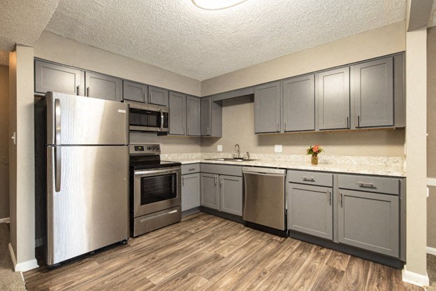 a kitchen with stainless steel appliances and gray cabinets