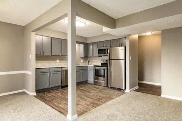 a renovated kitchen with stainless steel appliances and gray cabinets