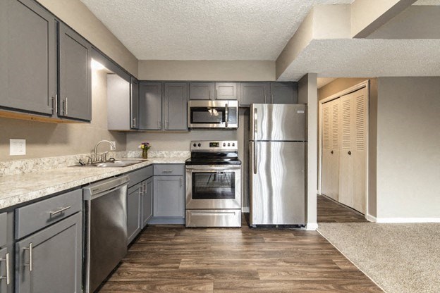 a kitchen with stainless steel appliances and white counter tops