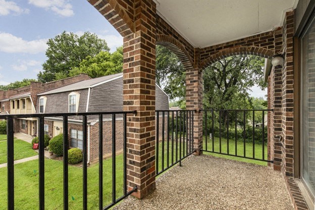 a balcony with a black fence and a brick house