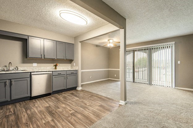 an open kitchen and living room with a sliding glass door