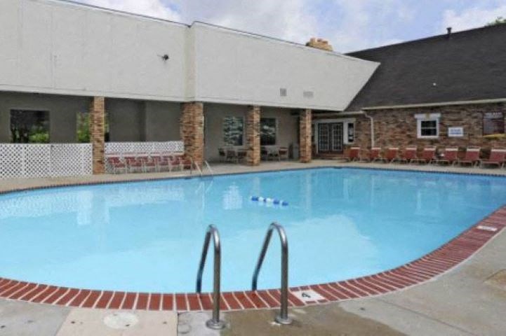 Outdoor pool with numerous seating options.  