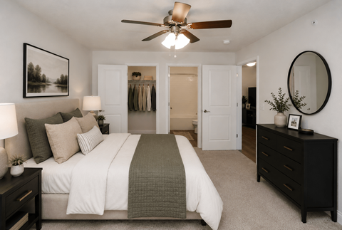 A bedroom with a large bed and a ceiling fan.