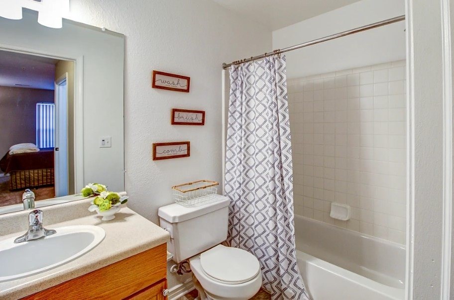 A white toilet sits next to a sink in a bathroom.