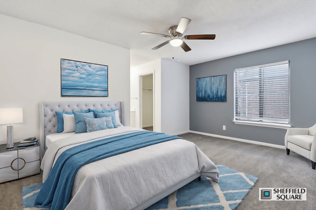 A bedroom with a large bed and a ceiling fan.