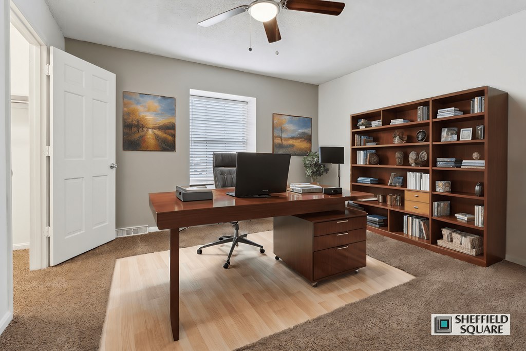 A room with a desk and a bookshelf.
