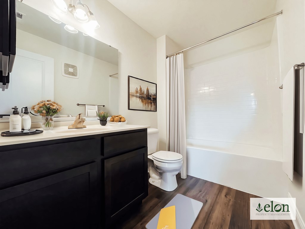 A bathroom with a toilet, sink, and mirror.