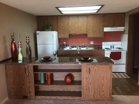 A kitchen with a white refrigerator and a wooden island.
