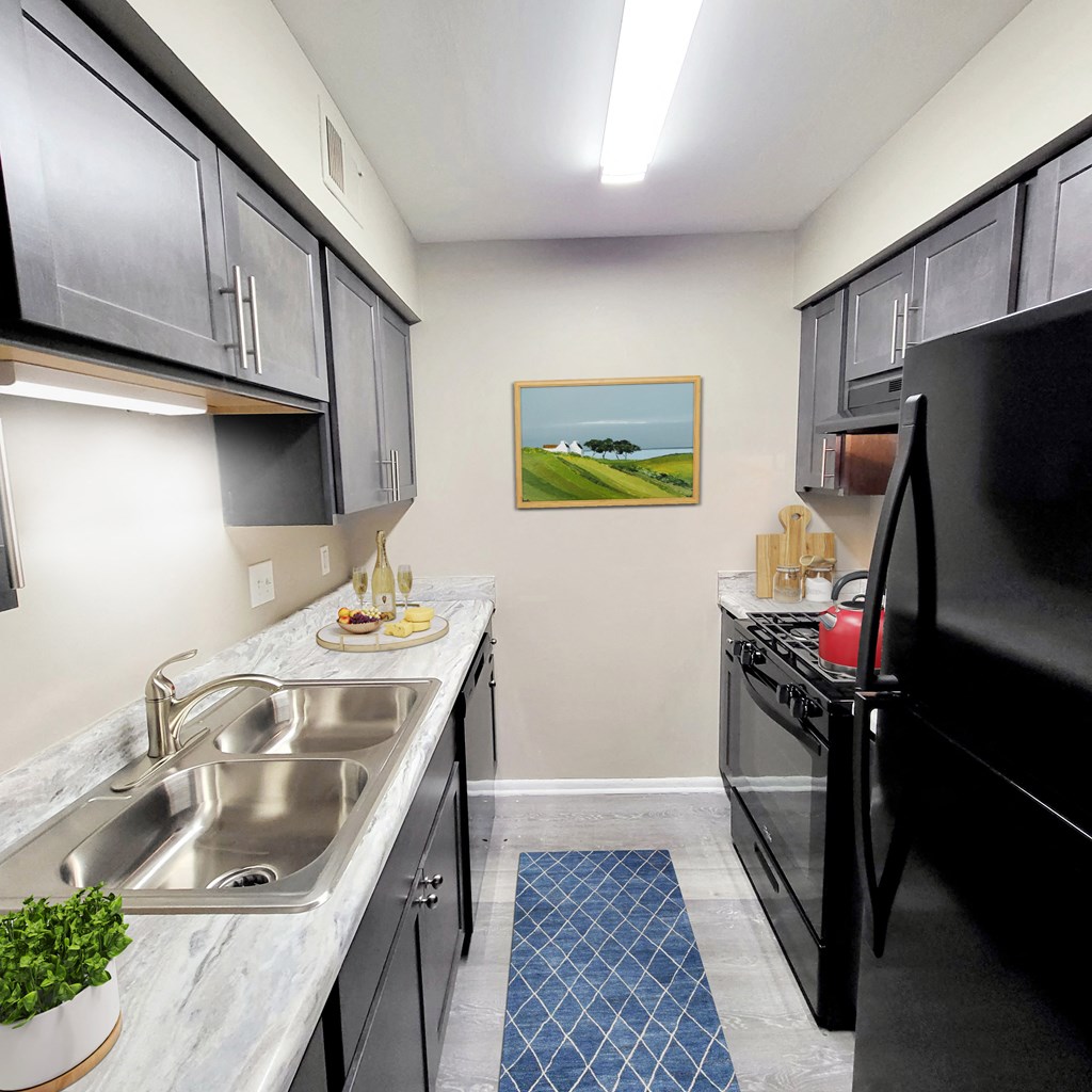 a kitchen with black appliances and a stainless steel sink