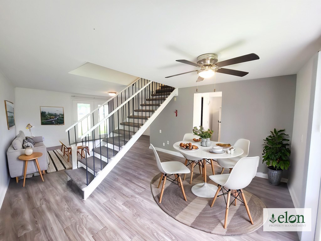 A dining room with a table set for four and a staircase at Townhomes at 28th, Columbus, Indiana