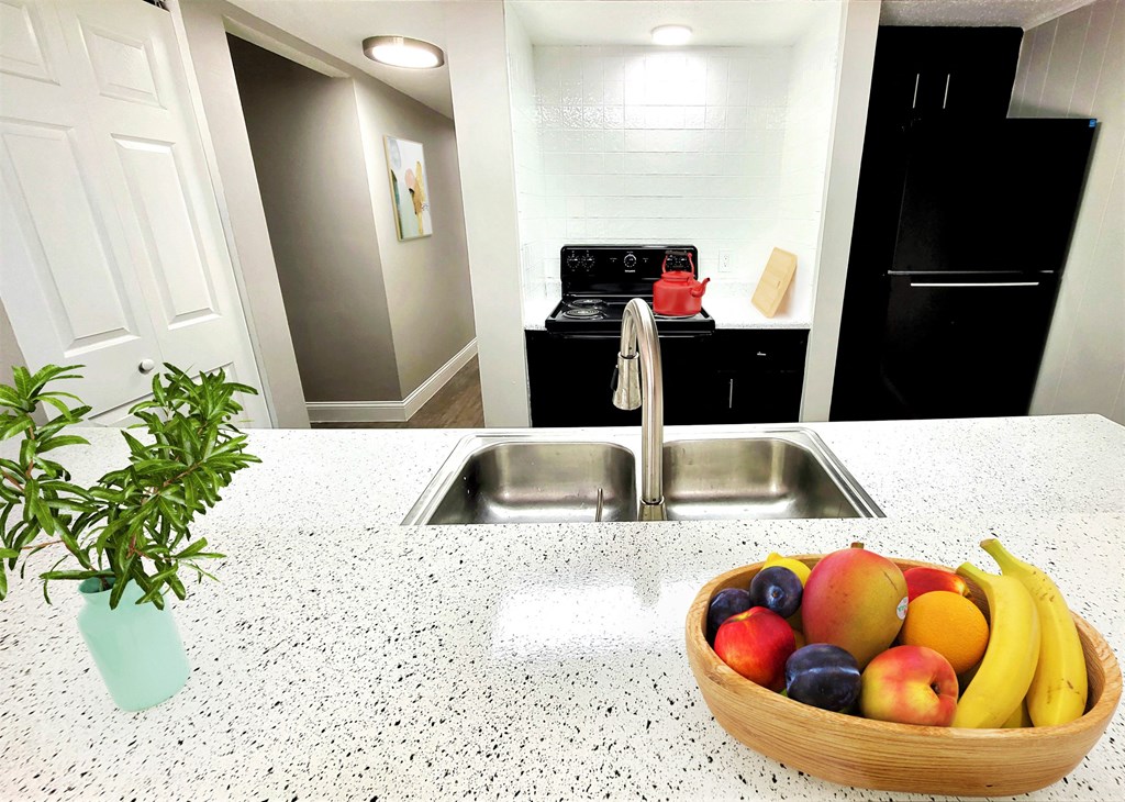 a kitchen with a bowl of fruit and a sink