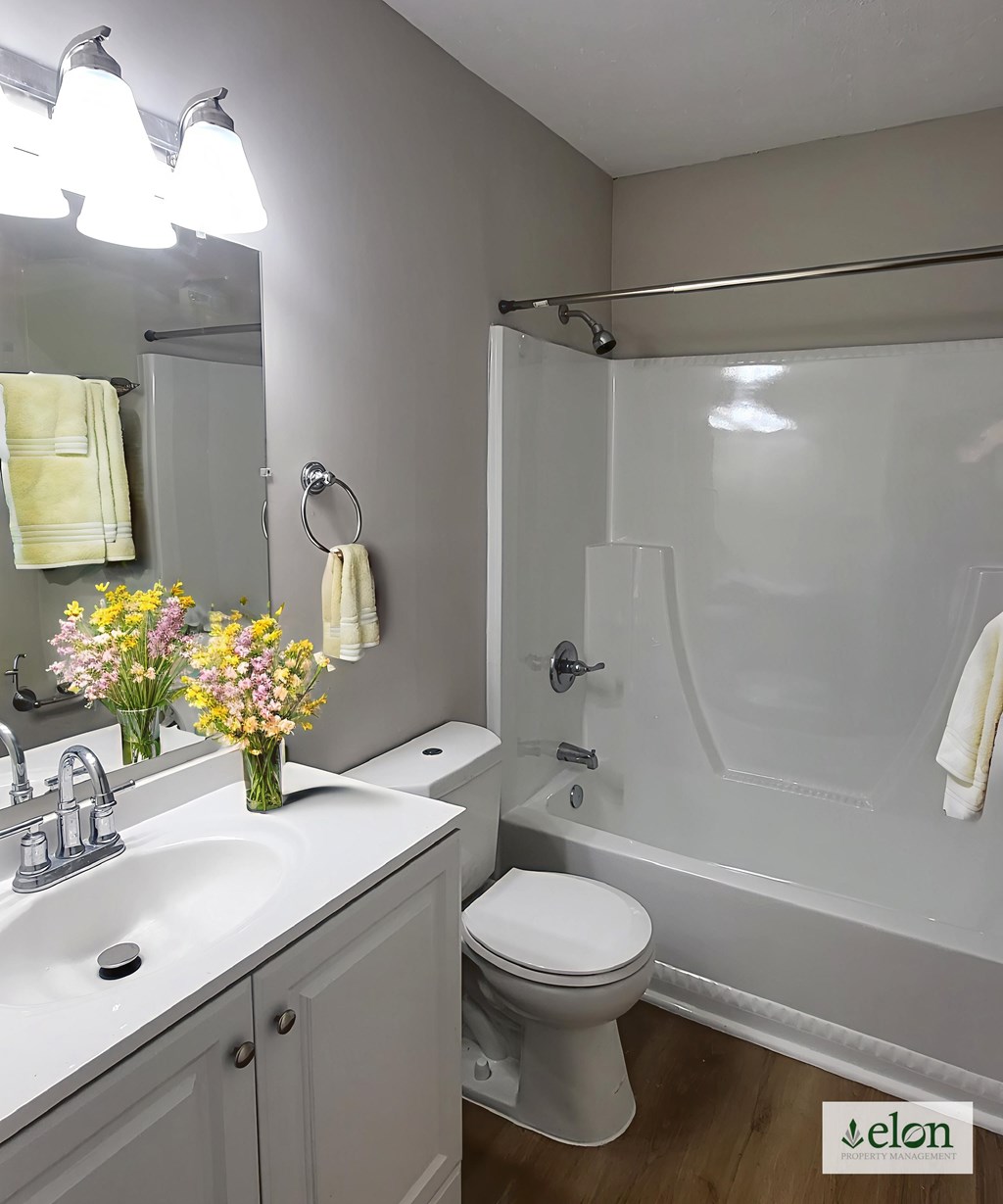 A white bathroom with a toilet, sink, and tub.