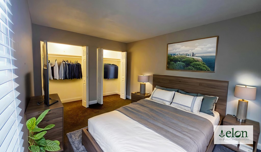 A bedroom with a large bed and a painting on the wall.