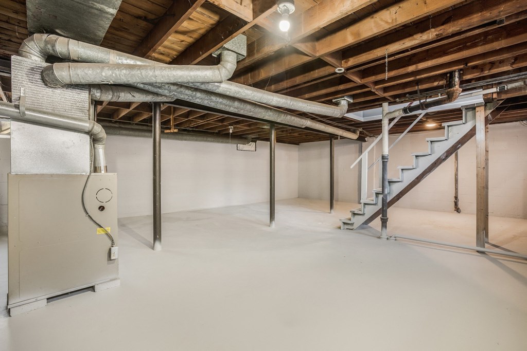 a large basement with pipes and a staircase in it