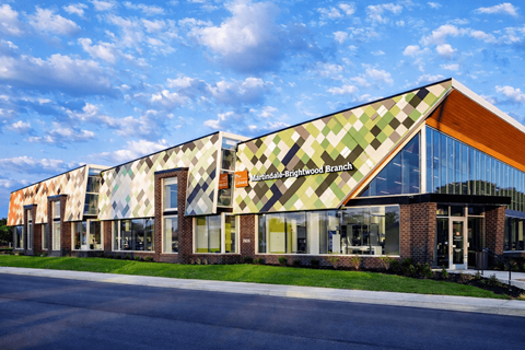 A modern building with a glass facade and a brick base.
