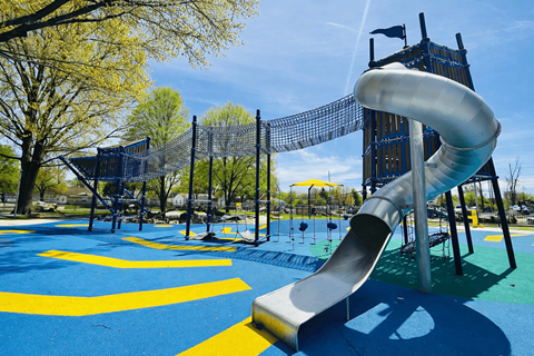 A playground with a slide and climbing net.