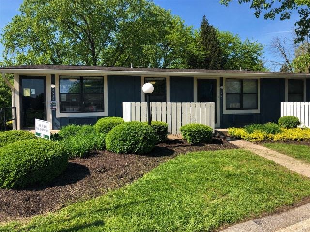 a blue house with a yard and a white fence