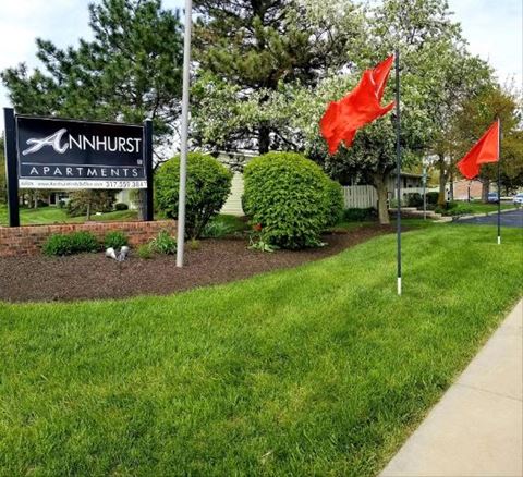 a lawn with two red flags and a sign
