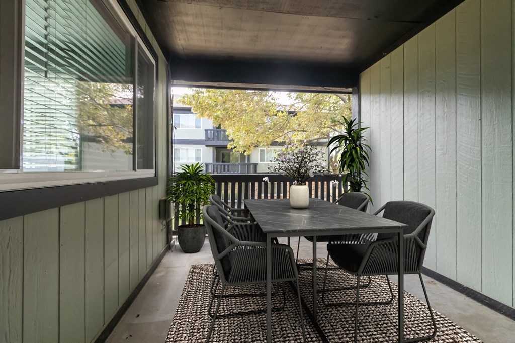 a patio with a table and chairs and a large window