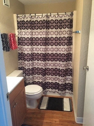 a bathroom with a toilet and a shower curtain