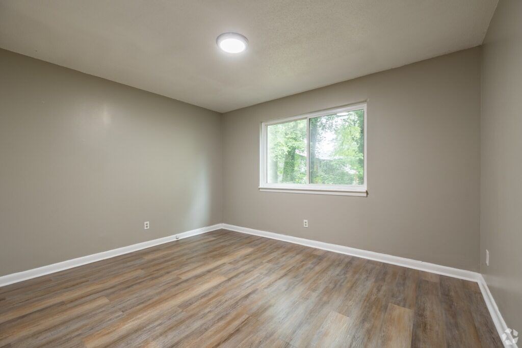 A room with wooden flooring and a window.