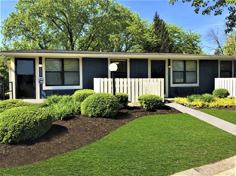 A house with a well-manicured lawn and a white lamp post.