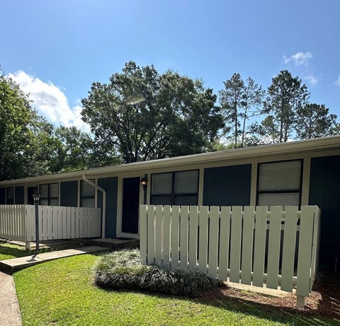 A white picket fence in front of a building.