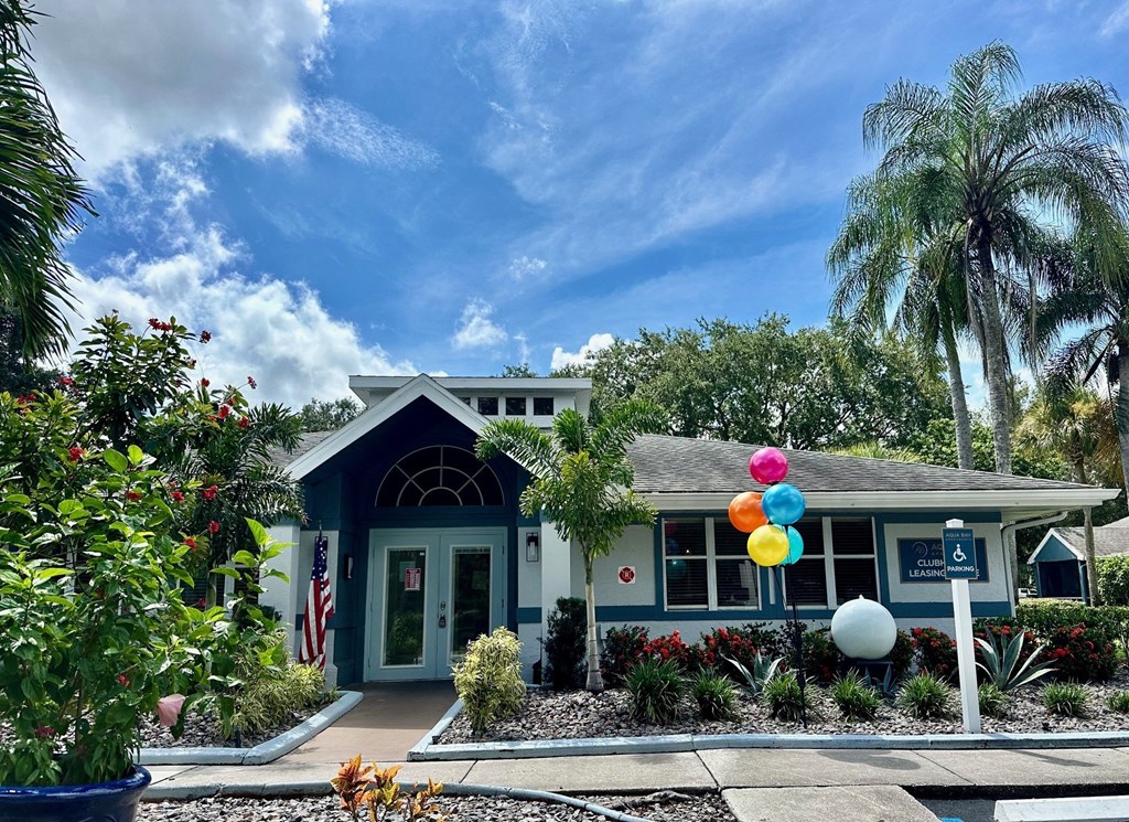 a blue house with colorful balloons in front of it at Aqua Bay Apartments in Naples, FL 34116
