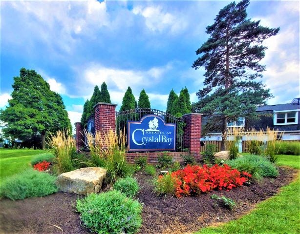 Estates at Crystal Bay sign with a variety of plants and flowers surrounding the sign. 
