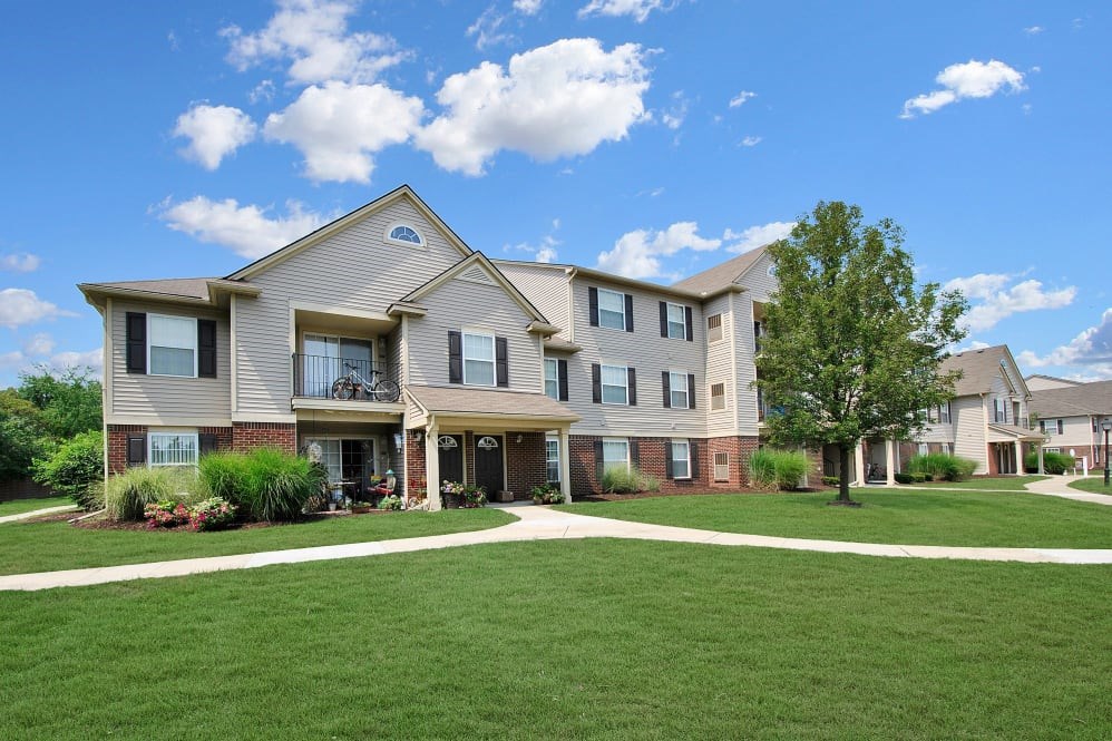 A large, modern house with a well-manicured lawn in front.