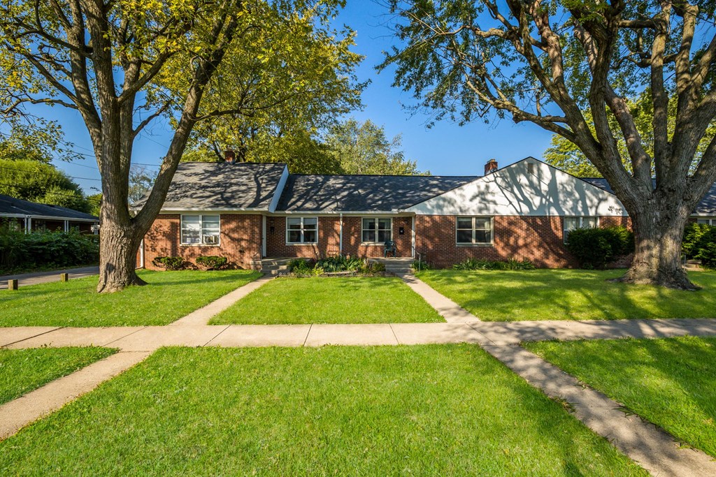 a red brick house with trees in front of it