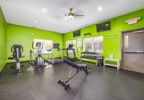 A gym with a variety of equipment including treadmills, stationary bikes, and weight machines.